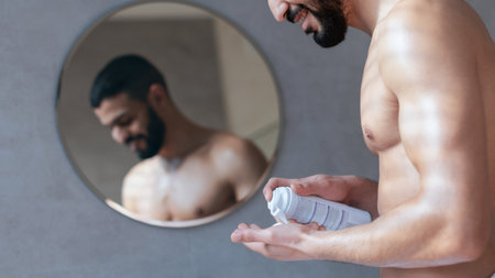 Man Applying Skincare Product in Front of Mirror During Morning Routineの写真素材