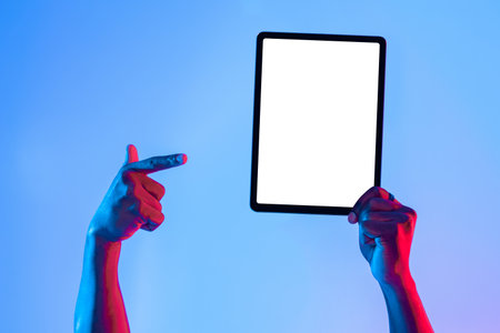 Hands Holding a Tablet in Bright Colors Against a Blue Background