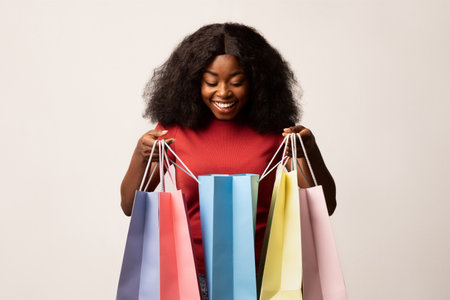 Excited Woman Exploring Vibrant Shopping Bags During Seasonal Sales Eventの写真素材