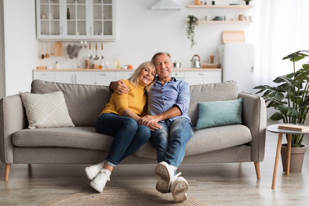 Senior Couple Enjoying Quality Time Together on a Cozy Sofa in a Bright Living Roomの写真素材