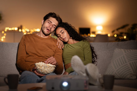 Couple Falls Asleep While Watching a Boring Movie at Home on Weekend Nightの写真素材