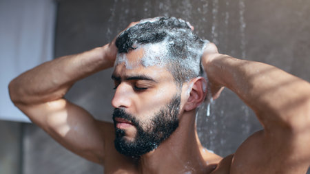 Man Washing Hair in Shower With Shampoo During Morning Routine at Homeの写真素材