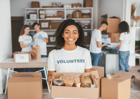 Volunteer Organizes Food Donations in a Community Center During a Charity Eventの写真素材