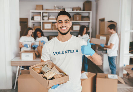 Volunteers Organize Food Donations in a Community Center While Smiling and Helping Othersの写真素材