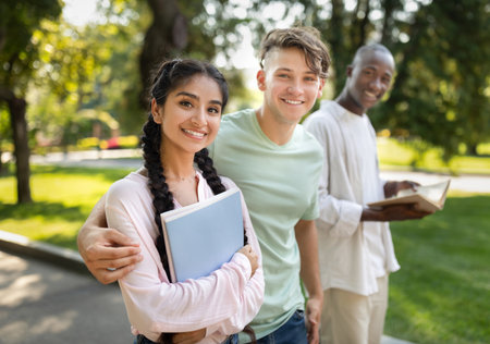 Students Enjoy a Sunny Afternoon in the Park While Studying Together and Sharing Smiles With Friendsの写真素材