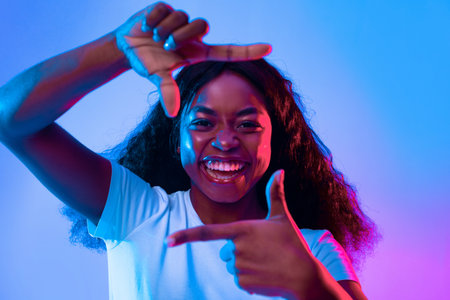 Young Woman Smiling and Posing With Hands in Colorful Lighting Setting