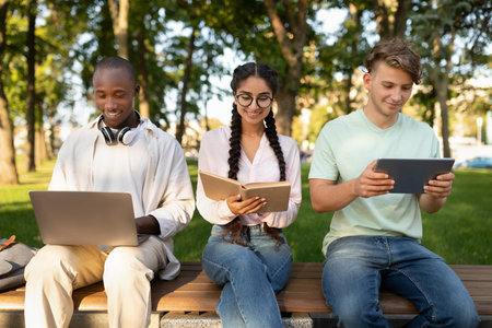 Young People Engaged in Learning and Technology at a Park During a Sunny Afternoonの写真素材