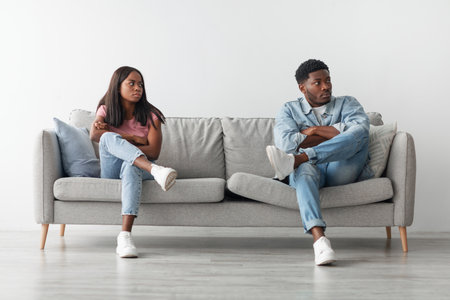 Young black couple having fight, ignoring each otherの写真素材