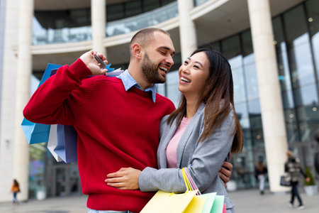 Couple Enjoying a Joyful Day of Shopping Together Outside a Modern Shopping Center in the Cityの写真素材