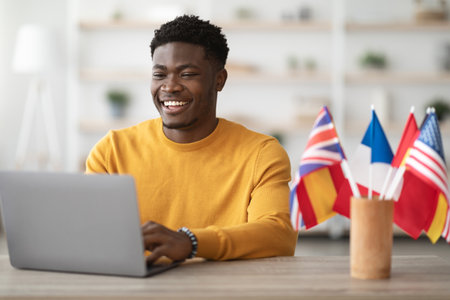 Happy black guy student studying at language school onlineの写真素材