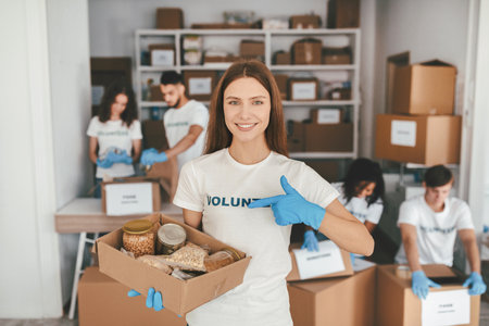 Group of Volunteers Sorting Food Donations in a Community Center During the Daytimeの写真素材
