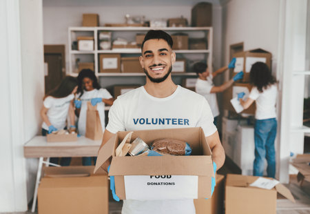 Volunteers Work Together Packing Food Donations in a Community Center for Those in Needの写真素材