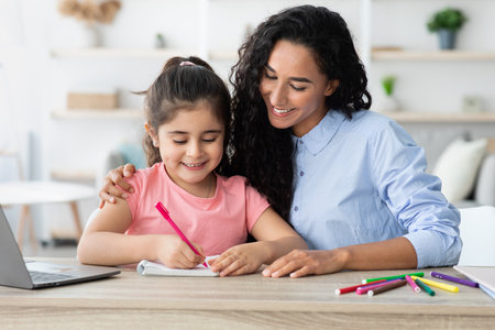 Mother and Daughter Enjoying Quality Time Together While Drawing at Home on a Sunny Afternoonの写真素材