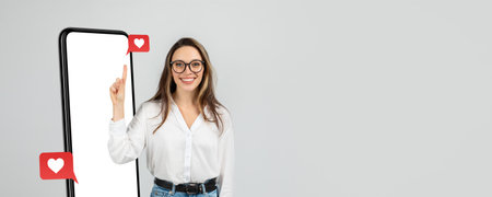 Smiling Woman Engages With Social Media App on Smartphone With Heart Icons in a Modern Settingの写真素材