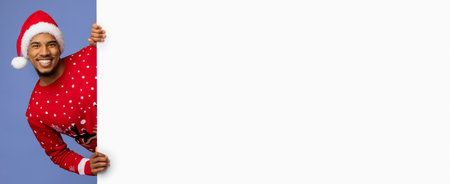 Man in Santa Hat and Festive Sweater Poses Cheerfully for Holiday Celebrationの写真素材