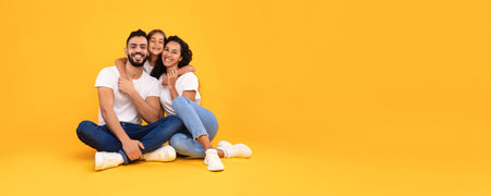 Family Poses Happily Together on a Bright Yellow Background During a Casual Moment of Joy and Connectionの写真素材