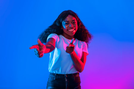 Young Woman Posing Playfully With a Bright Background in a Studio Settingの写真素材