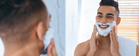 Man Shaving Carefully in a Bright Bathroom With a Mirror in the Morningの写真素材