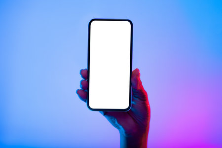 Hand Holding a Smartphone With a Blank Screen Against a Colorful Backgroundの写真素材