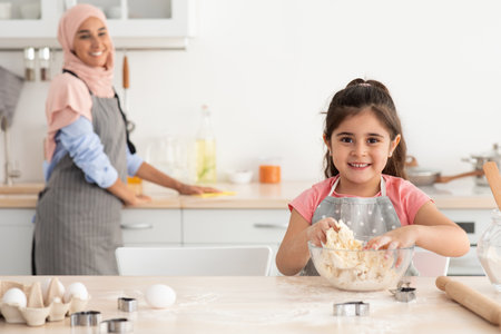 Mother and Daughter Baking Together in a Modern Kitchen During Afternoon Hours