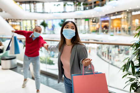 Shopping Day at the Mall With Friends Wearing Masks and Enjoying a Fun Experience Togetherの写真素材