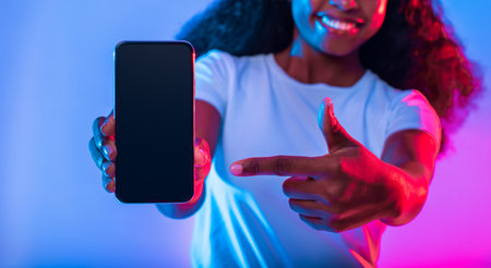 Woman Showcasing Smartphone With Colorful Lighting Effects in a Modern Setting