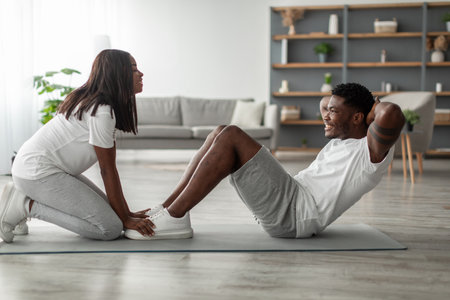 Young black couple doing sit-ups exercise on absの写真素材