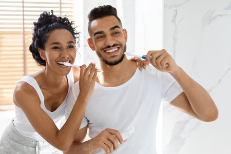 Couple Brushes Teeth Together in Bright Bathroom During Morning Routineの写真素材