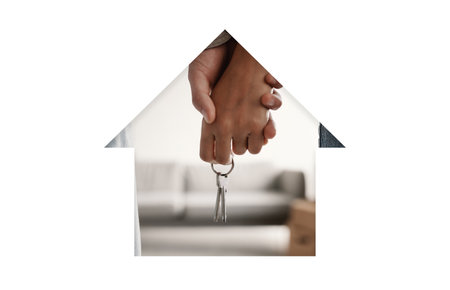 Holding Hands and Keys Symbolizing New Beginnings in a Cozy Home Settingの写真素材