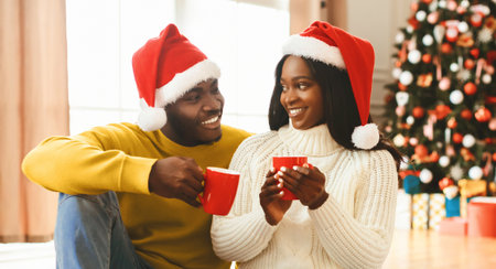 Couple Enjoys Hot Drinks by Christmas Tree in Cozy Room During Holiday Seasonの写真素材