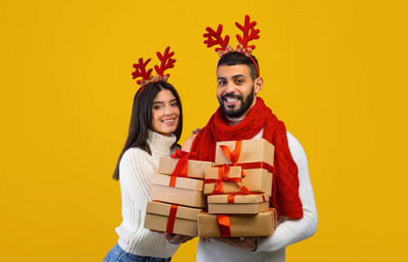 Happy Couple Celebrating Holidays With Presents Against Bright Yellow Backgroundの写真素材