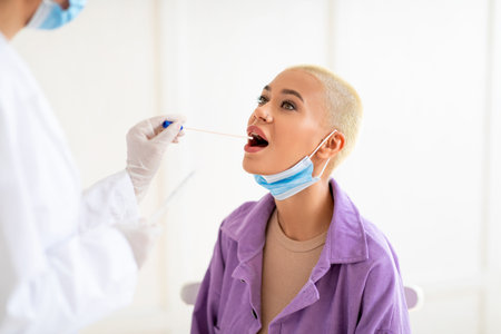 Millennial lady doing pcr test, getting oral coronavirus swab test, female doctor in protective...