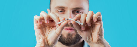 Man Breaking a Cigarette to Symbolize Quitting Smoking for Better Healthの写真素材