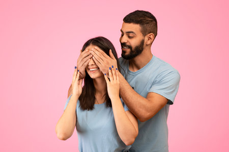Couple Enjoying a Playful Moment While Posing Against a Pink Background