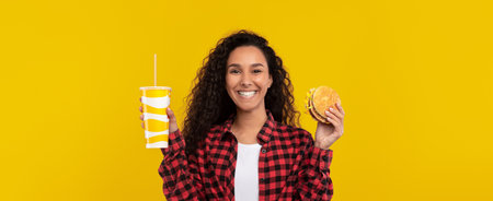 Enjoying a Tasty Burger and Drink Against a Vibrant Yellow Background