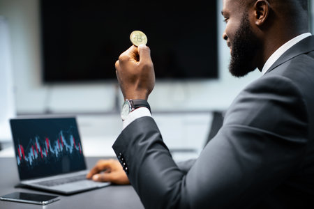 Businessman Holds Bitcoin While Analyzing Market Data in an Office Setting During the Dayの写真素材
