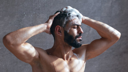 Man Enjoying a Refreshing Shower While Lathering His Hair With Shampoo