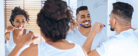 Couple Enjoying Morning Routine While Brushing Teeth Together in Bathroomの写真素材