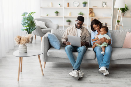 Family Enjoying Educational Game Together on Laptop in Cozy Living Room at Homeの写真素材
