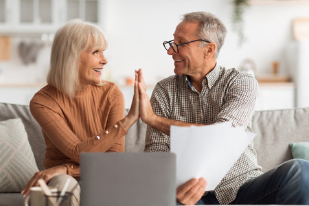 Happy Couple Enjoying a Joyful Moment Together While Discussing Important Documents at Home