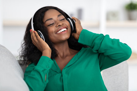 Enjoying Music While Relaxing at Home in a Cozy Setting With Headphones Onの写真素材