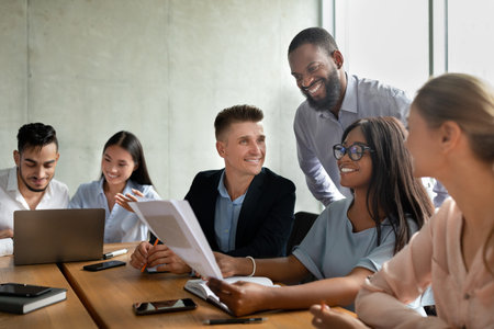Young Business Professionals Engaging in Conversation During a Corporate Meeting at the Officeの写真素材