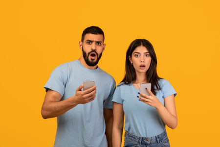 Shocked Couple Reacts to News on Phones in Bright Yellow Studio