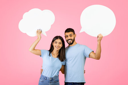 Young Couple Enjoying Fun Conversation With Speech Bubbles Against a Pink Background