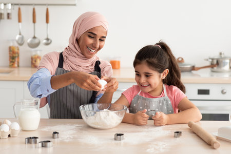 Mother and Daughter Baking Together in a Cozy Kitchen While Making Cookies With Eggs and Flour in...
