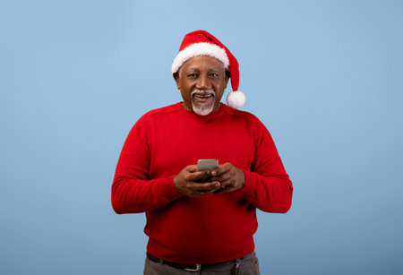 Man Smiles While Holding a Smartphoneの写真素材