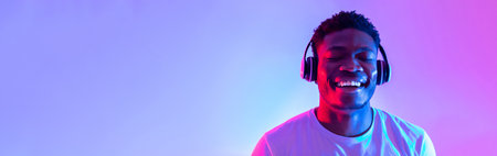 Young Black Man Enjoys Music With Headphones in Vibrant Neon Light Setting