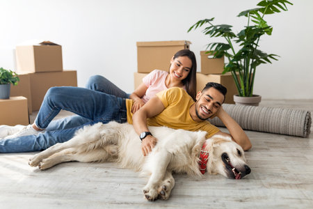 Couple Relaxing With Their Dog in New Home Surrounded by Moving Boxesの写真素材