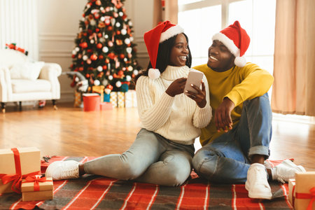 Couple Enjoying Time Together During Holiday Season With Gifts and Christmas Tree in Backgroundの写真素材
