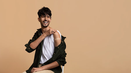 Man Showing Vaccination Bandage With a Smile in a Studio Setting